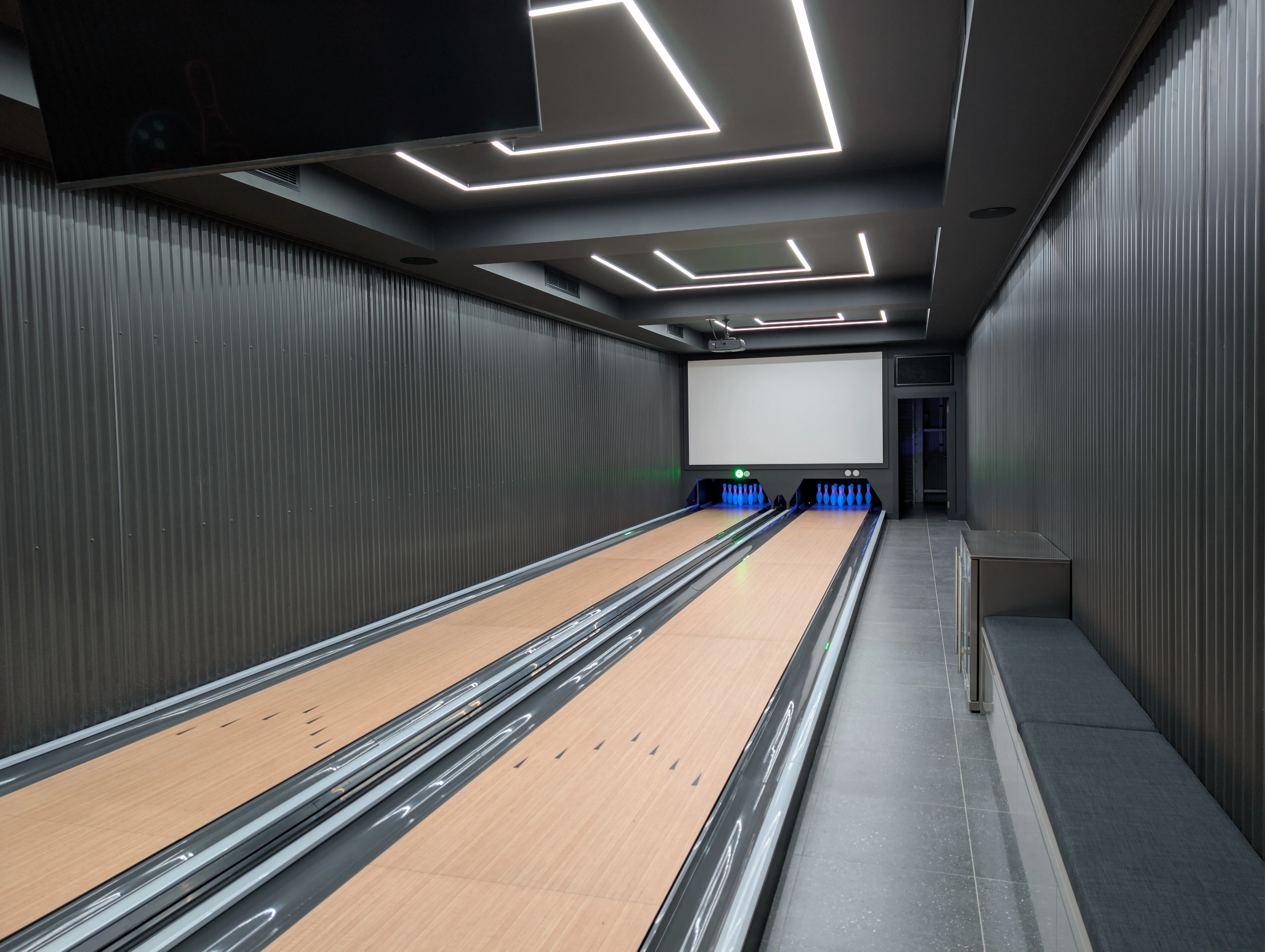 Two private bowling lanes running the length of a dark charcoal entertainment shed