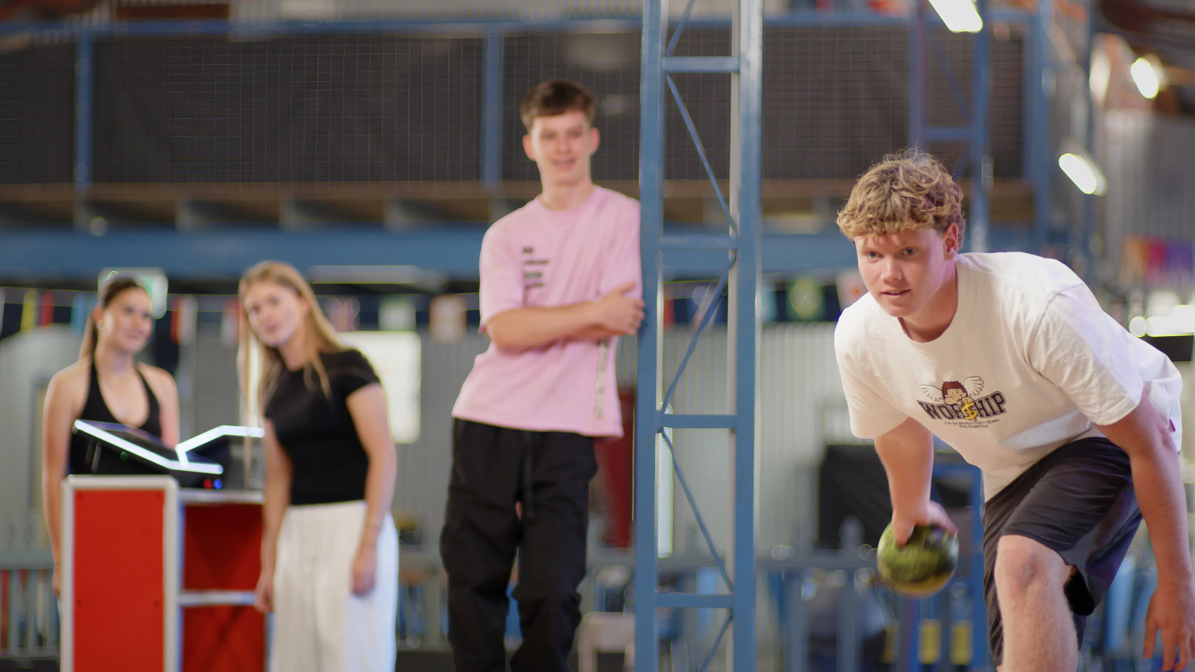 Player releasing the ball while friends watch from the scoring area
