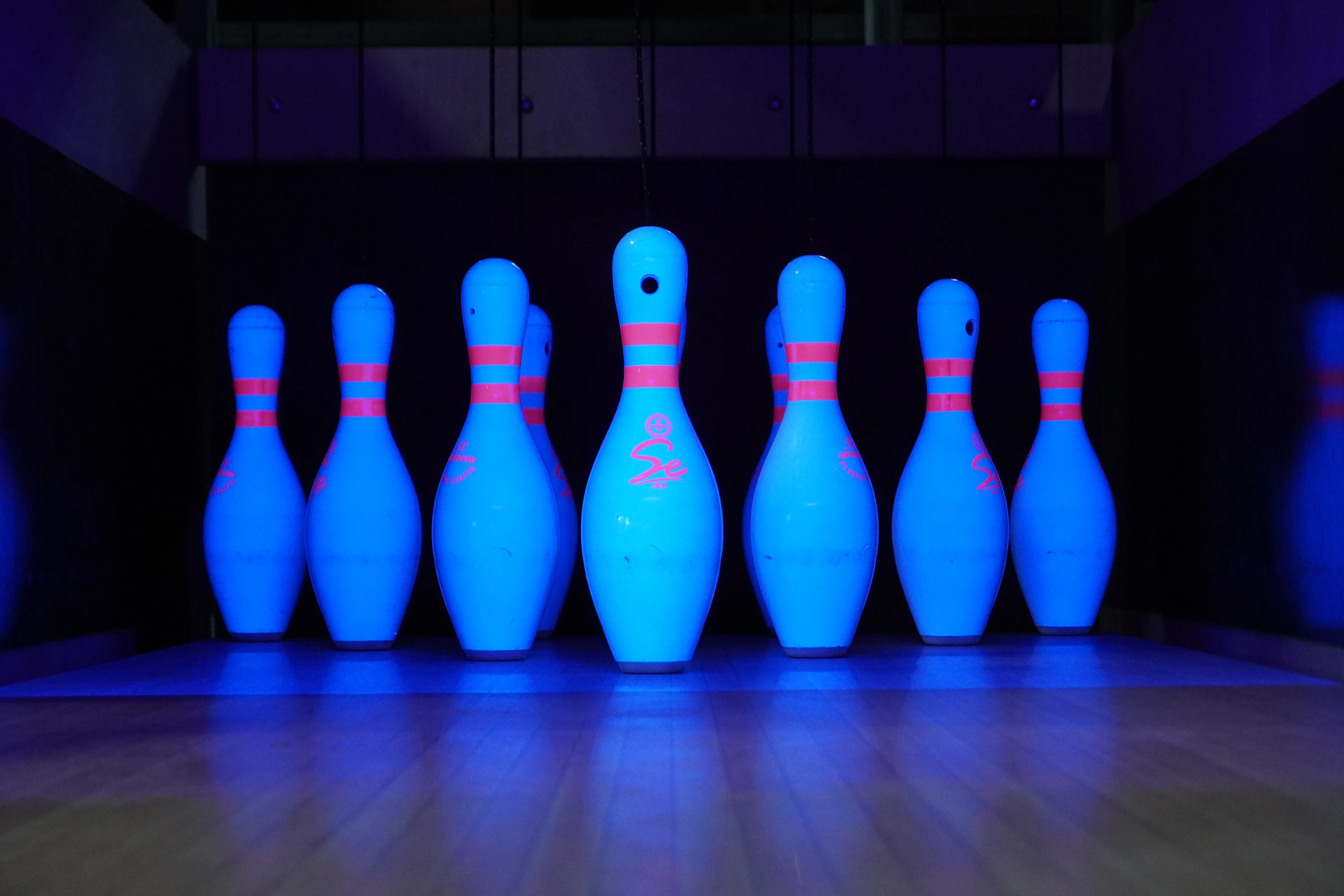 Bowling pins under ultraviolet lighting in a private LaneCraft installation