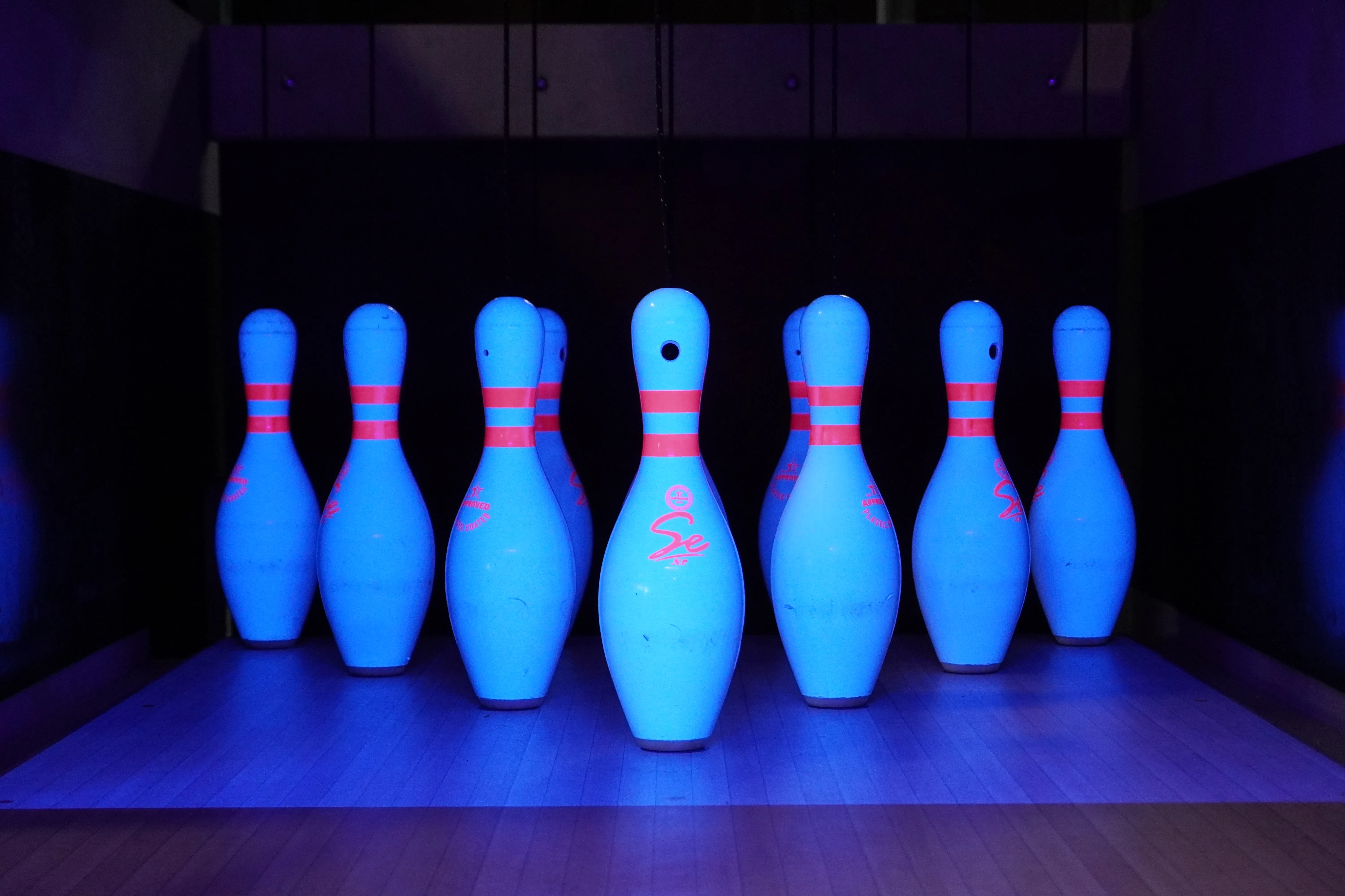 Ninepin bowling pins illuminated by ultraviolet lighting in a LaneCraft installation