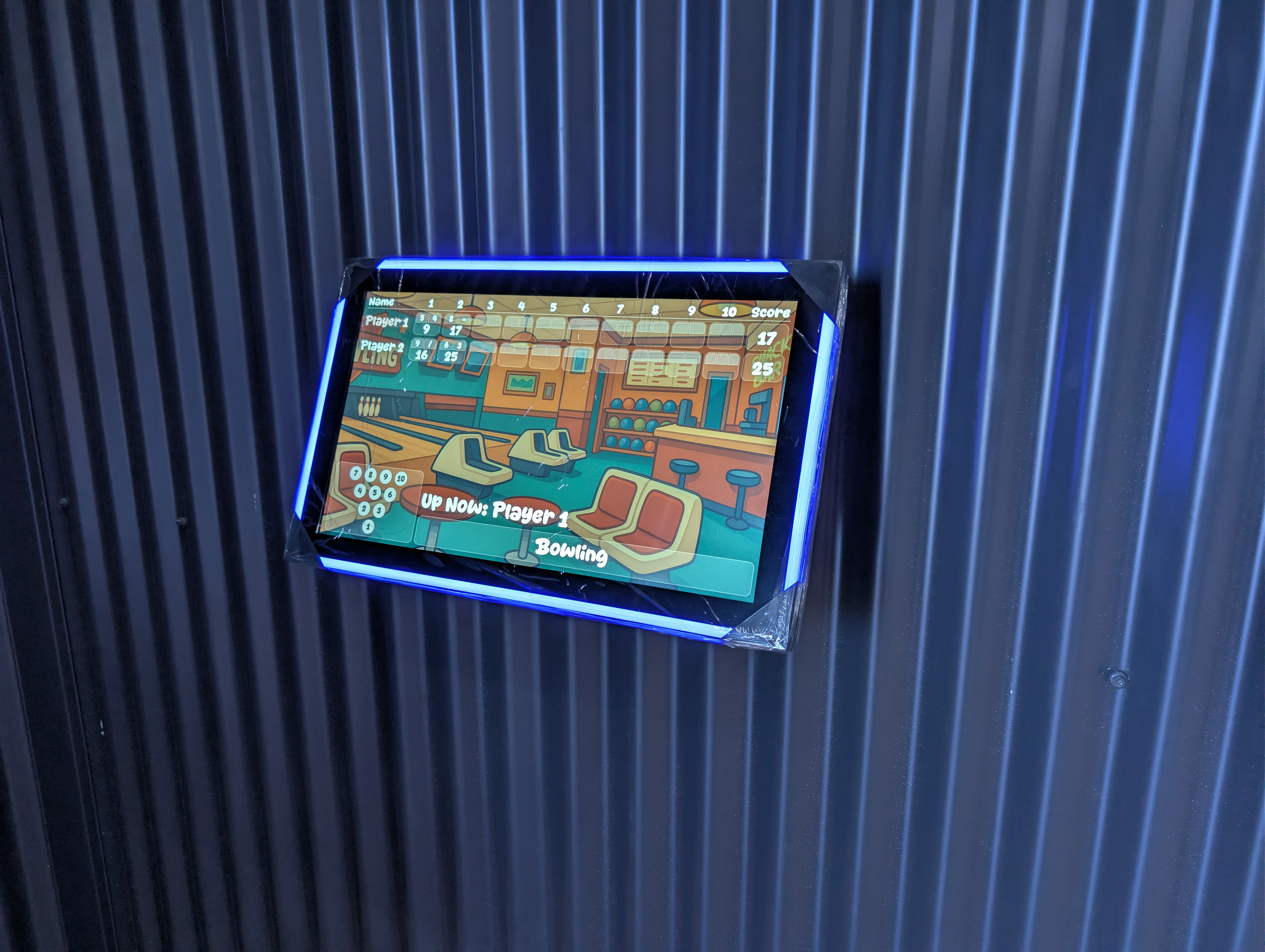 LaneCraft's bowling game interface displayed on a wall-mounted screen